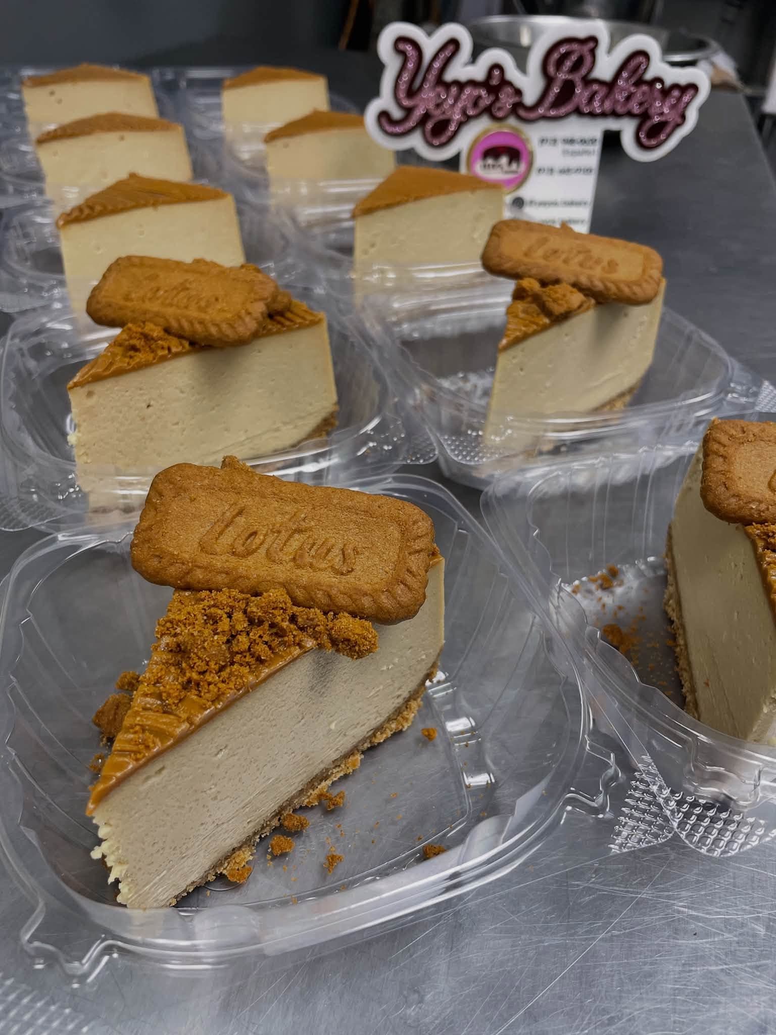 Slices of Biscoff cheesecake boxed in to-go containers at the counter, beside the Yeyo's Bakery sign.