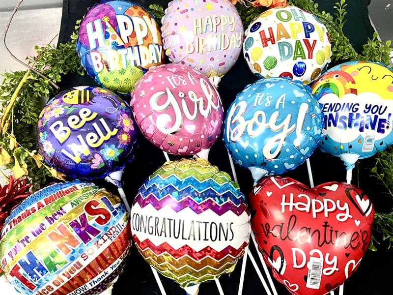 A bunch of celebration balloons — birthday, congratulations, it's a girl, it's a boy.
