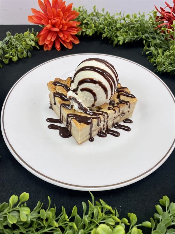 Warm chocolate chip bread pudding served with vanilla ice cream and chocolate sauce.