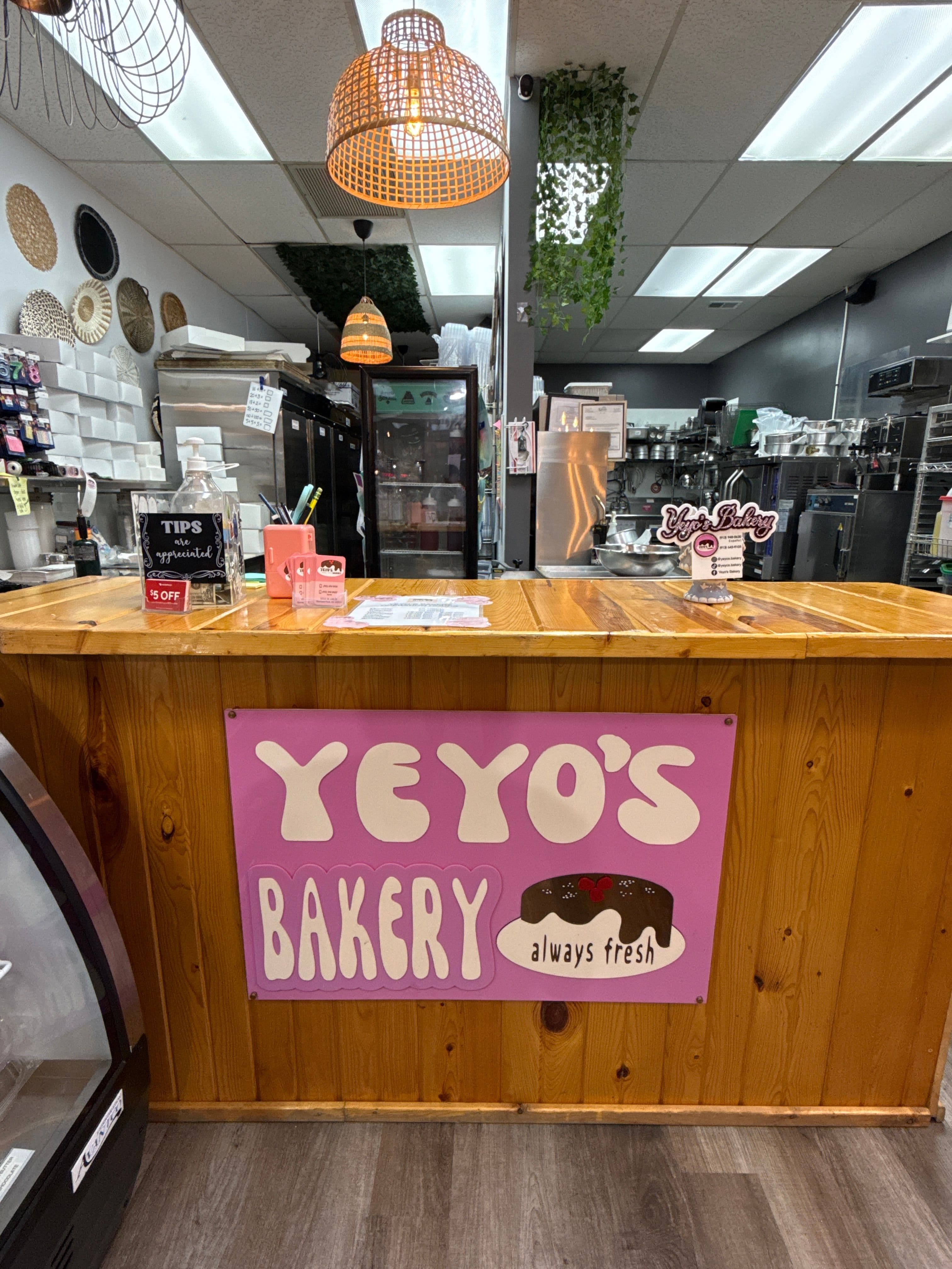 The front counter at Yeyo's Bakery in Overland Park, beneath the hand-painted 'Yeyo's Bakery — always fresh' sign.