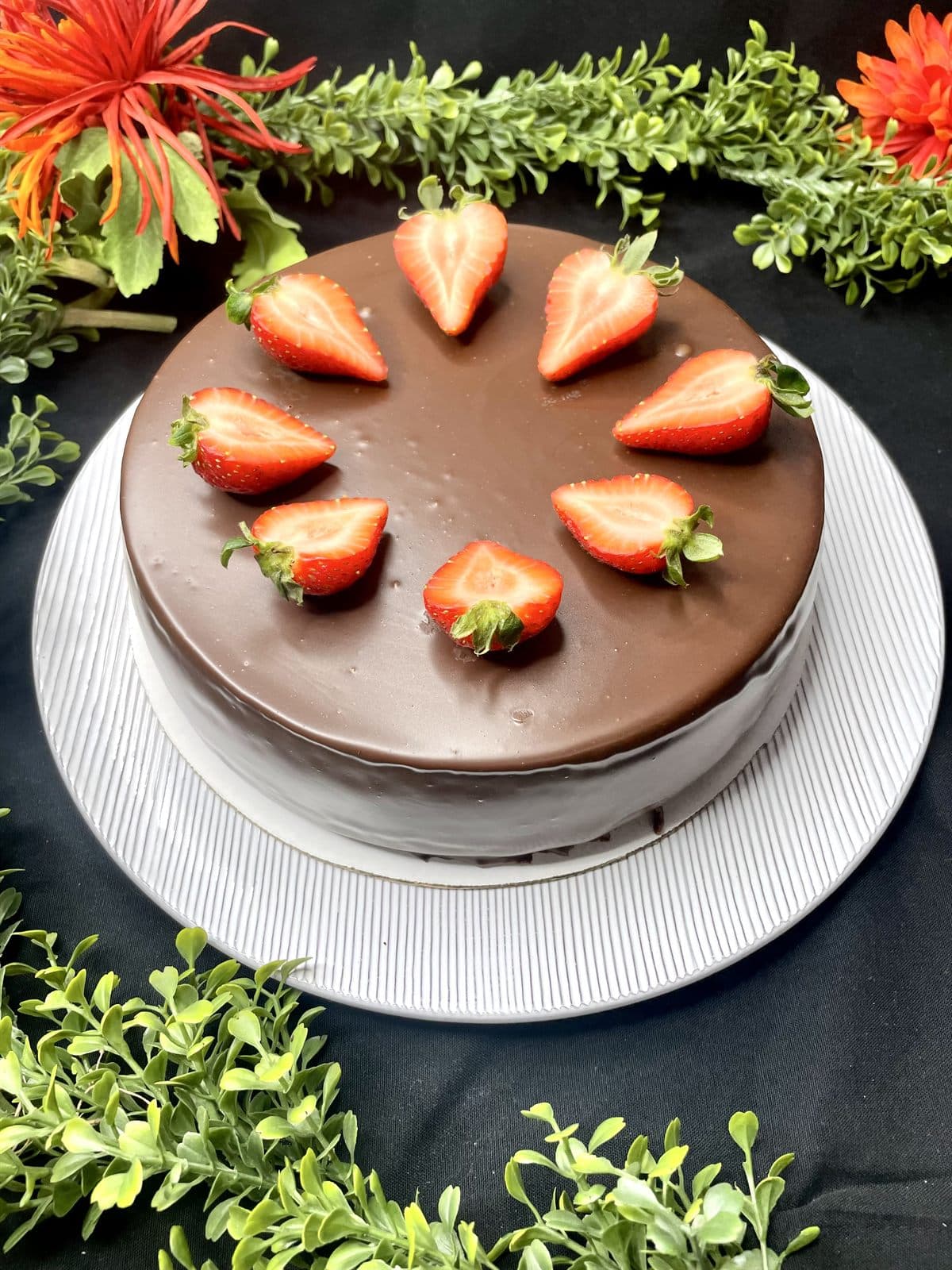 A whole chocolate-ganache cheesecake crowned with a ring of halved fresh strawberries.